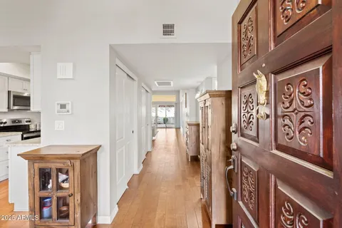 a view of a hallway with wooden floor and staircase