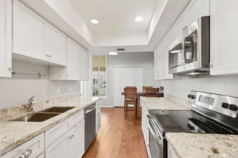 a kitchen with stainless steel appliances kitchen island granite countertop a sink stove and cabinets