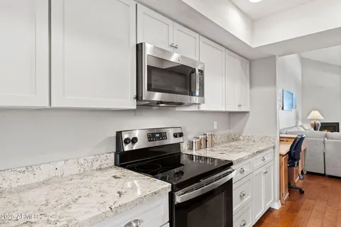 a kitchen with stainless steel appliances a stove a microwave a sink and cabinets
