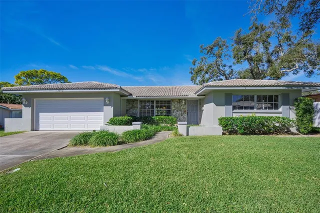 a front view of a house with a garden and plants