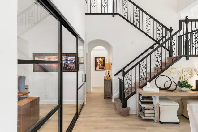 a view of staircase with lots of frames on wall and a window