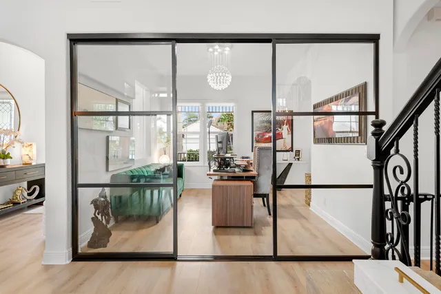a living room with furniture a flat screen tv and a floor to ceiling window