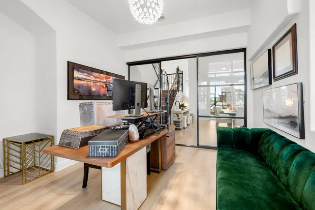 a kitchen with stainless steel appliances kitchen island granite countertop a stove a sink and white cabinets with wooden floor