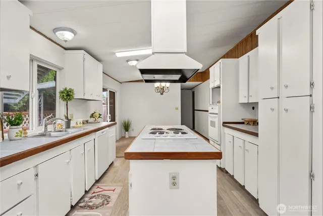 a kitchen with white cabinets stainless steel appliances and sink