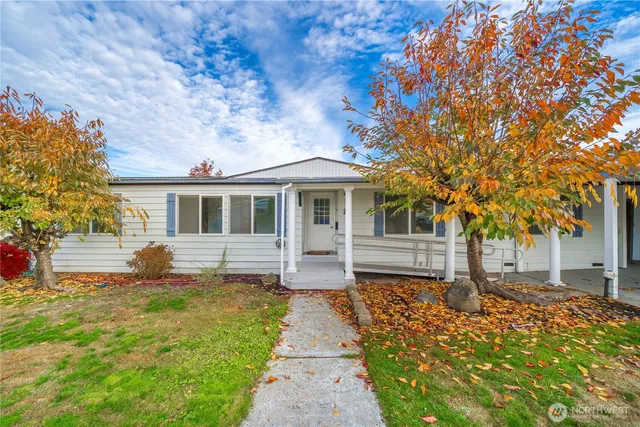a front view of a house with a garden and trees