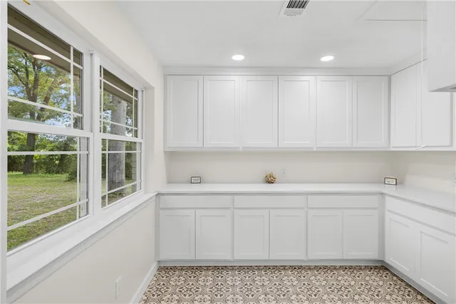 a kitchen with stainless steel appliances white cabinets and a window