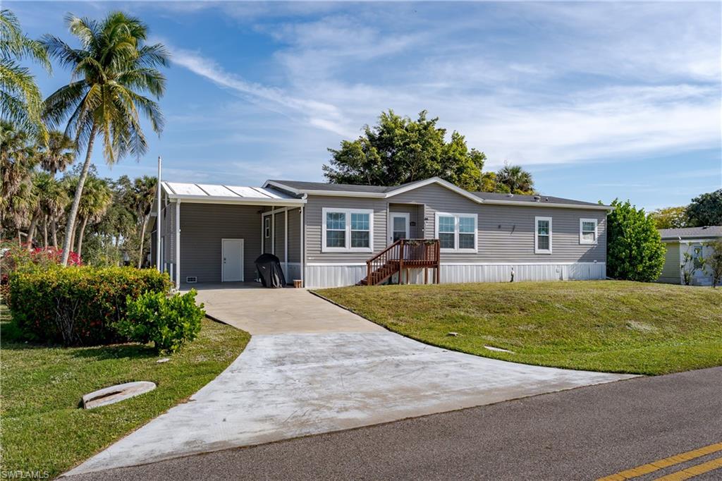 a front view of a house with a garden and trees