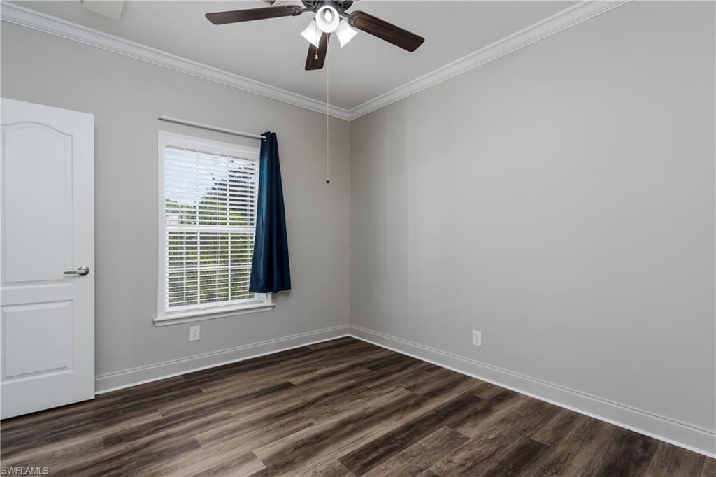 104 Rookery Road Naples, FL 34114 - Photo 19 of 32 a view of an empty room with wooden floor and a window