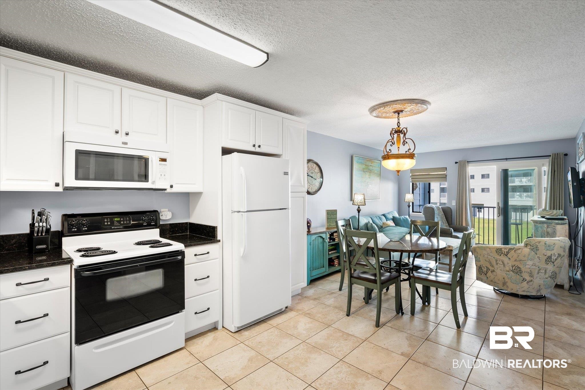 400 Plantation Road, Unit 3222 Gulf Shores, AL 36542 - Photo 5 of 31 Kitchen with white appliances, light tile patterned floors, pendant lighting, and white cabinetry