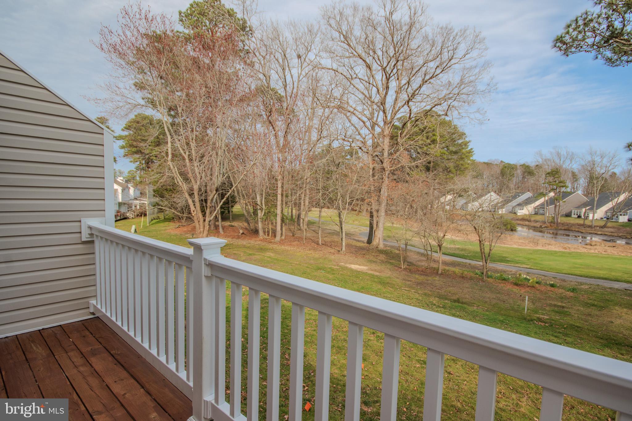 11610 Masters Lane, Unit 115 Berlin, MD 21811 - Photo 21 of 46 a view of a wooden deck with trees in front of house