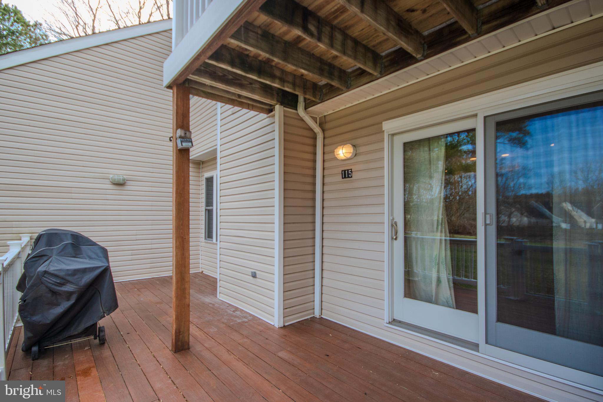 11610 Masters Lane, Unit 115 Berlin, MD 21811 - Photo 34 of 46 a view of a porch with furniture and wooden floor