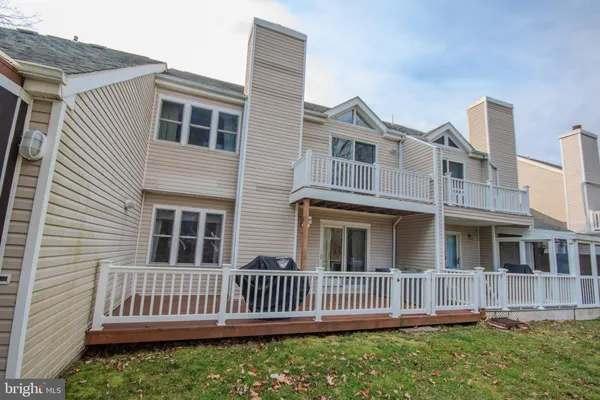 a view of a house with a small yard and wooden fence
