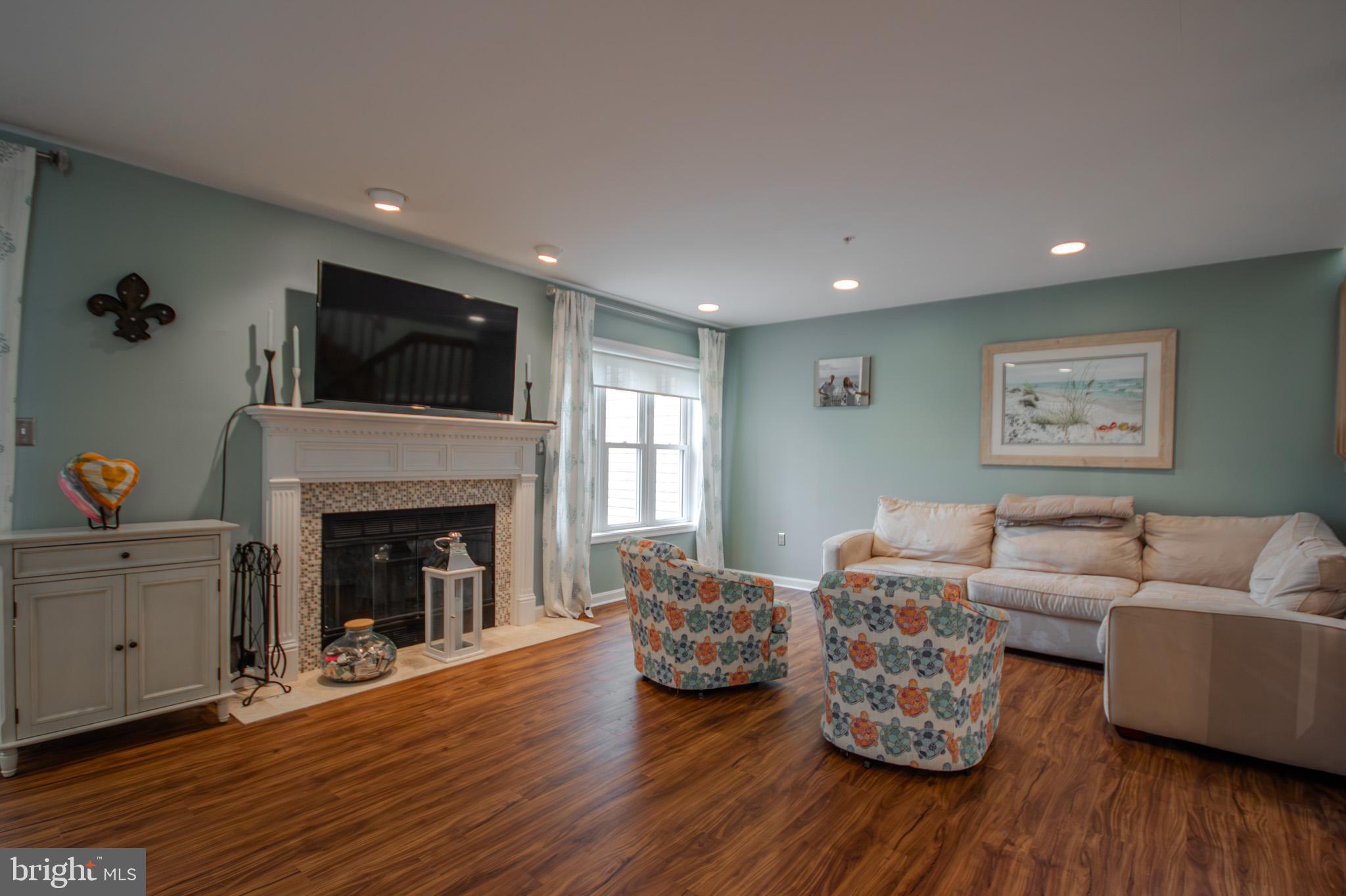 11610 Masters Lane, Unit 115 Berlin, MD 21811 - Photo 6 of 46 a living room with furniture fireplace and flat screen tv