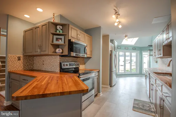 a kitchen with stainless steel appliances a microwave a stove and a sink