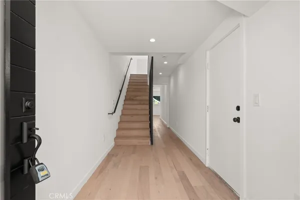 a view of a hallway with wooden floor and staircase