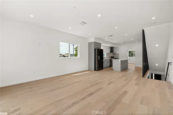 a view of kitchen with refrigerator stove and wooden floor
