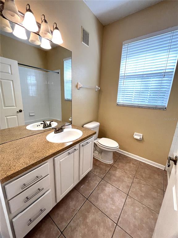588 Brantley Terrace Way, Unit 309 Altamonte Springs, FL 32714 - Photo 15 of 17 a bathroom with a granite countertop sink a toilet and a mirror