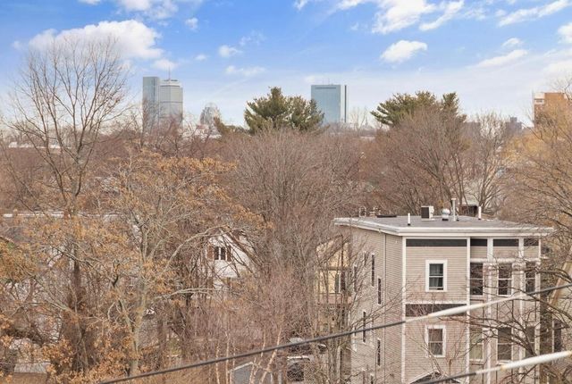 a view of a white house next to a road and a building