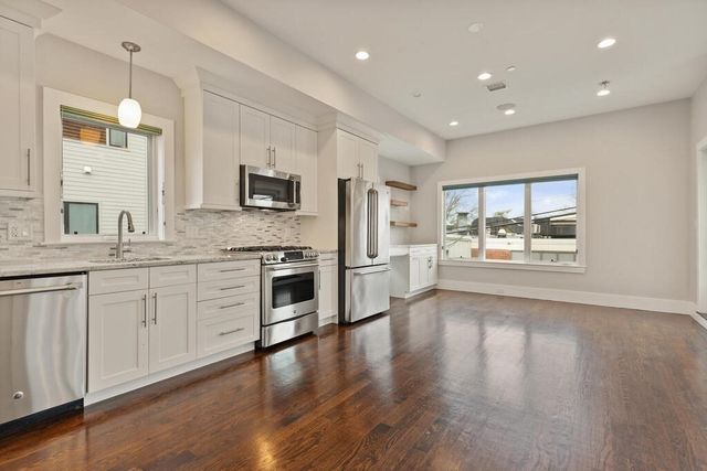 a large white kitchen with a stove a sink and a refrigerator
