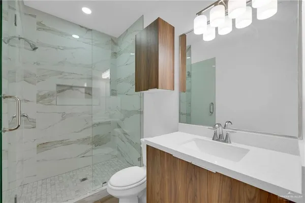 a bathroom with a sink a toilet and shower