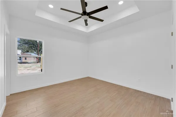an empty room with a window and a fan