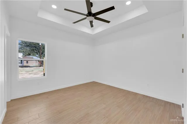 an empty room with a window and a fan