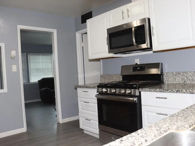 a kitchen with stainless steel appliances a stove a microwave and cabinets
