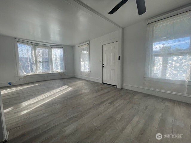 303 Methow Street Wenatchee, WA 98801 - Photo 3 of 14 an empty room with wooden floor and windows