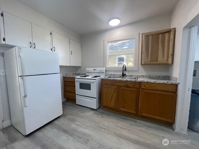 303 Methow Street Wenatchee, WA 98801 - Photo 5 of 14 a kitchen with granite countertop a sink cabinets stainless steel appliances and a window