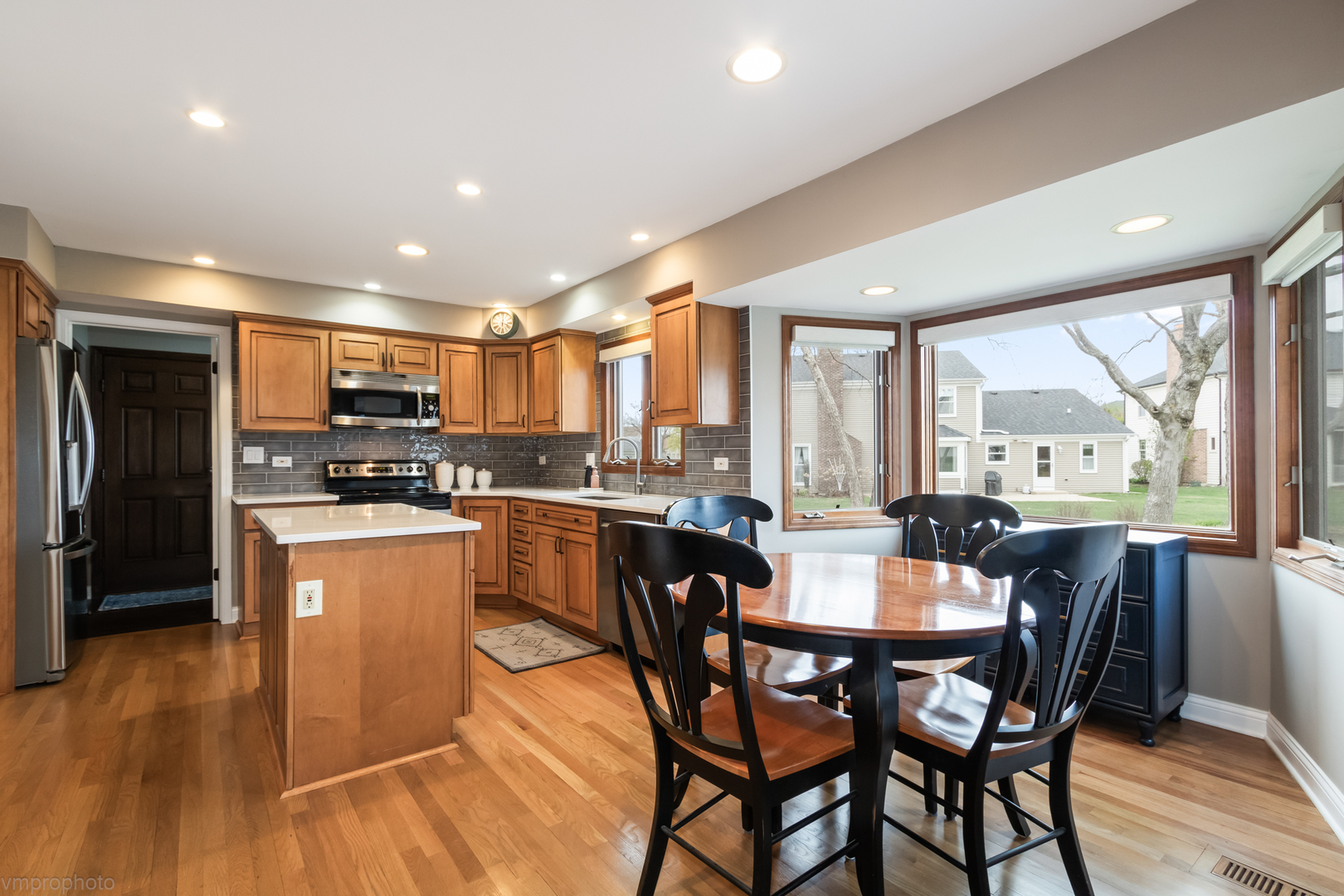 3963 Bordeaux Drive Hoffman Estates, IL 60192 - Photo 11 of 33 a kitchen with stainless steel appliances granite countertop a stove a refrigerator a kitchen island with a table and chairs