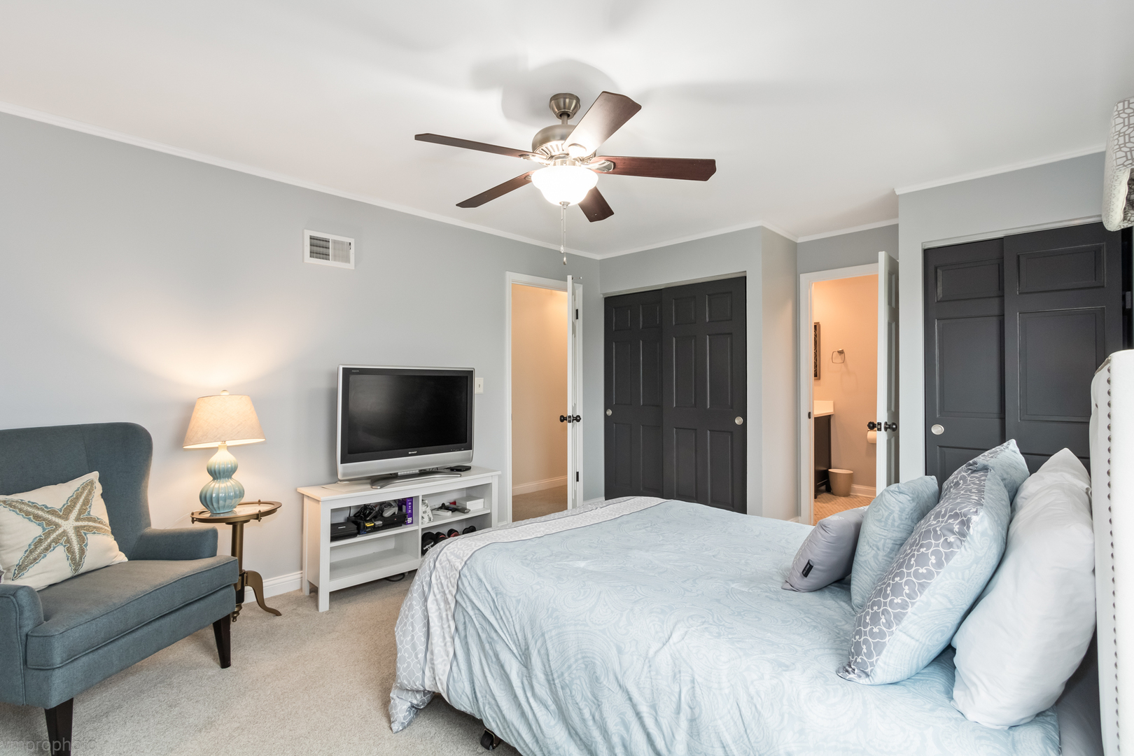 3963 Bordeaux Drive Hoffman Estates, IL 60192 - Photo 16 of 33 a bedroom with a bed flat screen tv and a chandelier
