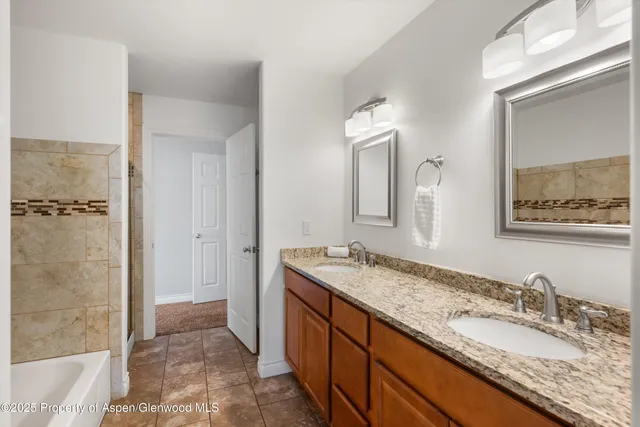 a bathroom with a granite countertop sink mirror and double