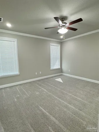 an empty room with windows and fan
