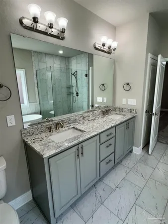 a bathroom with a granite countertop sink a large mirror and a shower