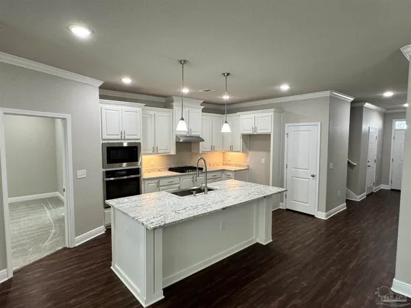a kitchen with a refrigerator a sink and wooden floor