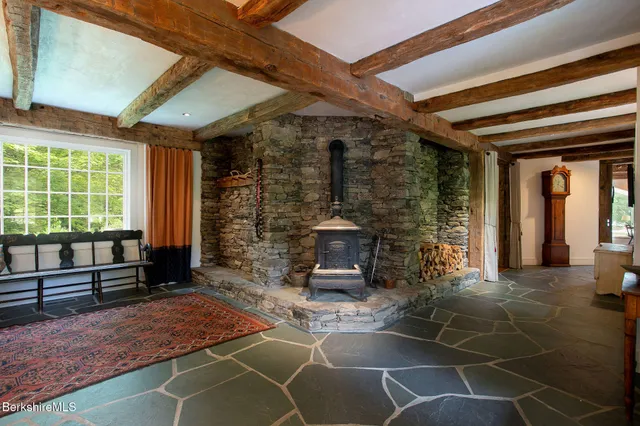 a living room with furniture a fireplace and next to a window
