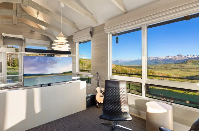 a room with furniture pool table and large windows