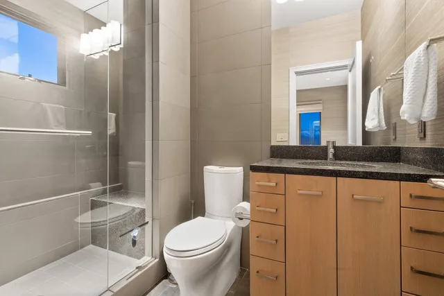 a bathroom with a sink a toilet and shower