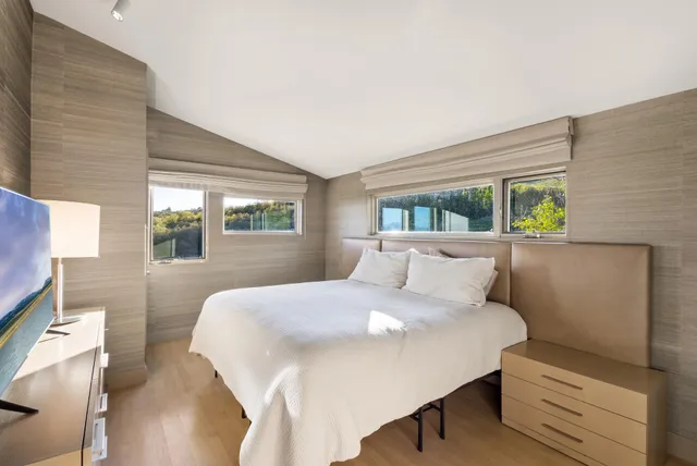 a bedroom with a large bed and a window