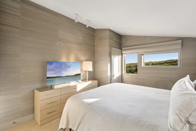 a bedroom with a bed and a flat screen tv