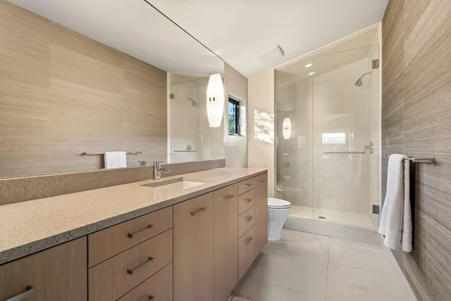a spacious bathroom with a double vanity sink toilet and shower