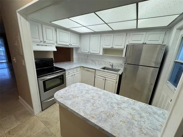a kitchen with a sink a refrigerator and cabinets