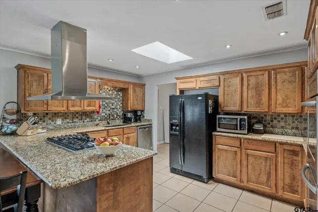 a kitchen with stainless steel appliances granite countertop a sink refrigerator and cabinets