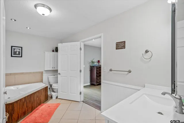 a bathroom with a tub sink and a mirror