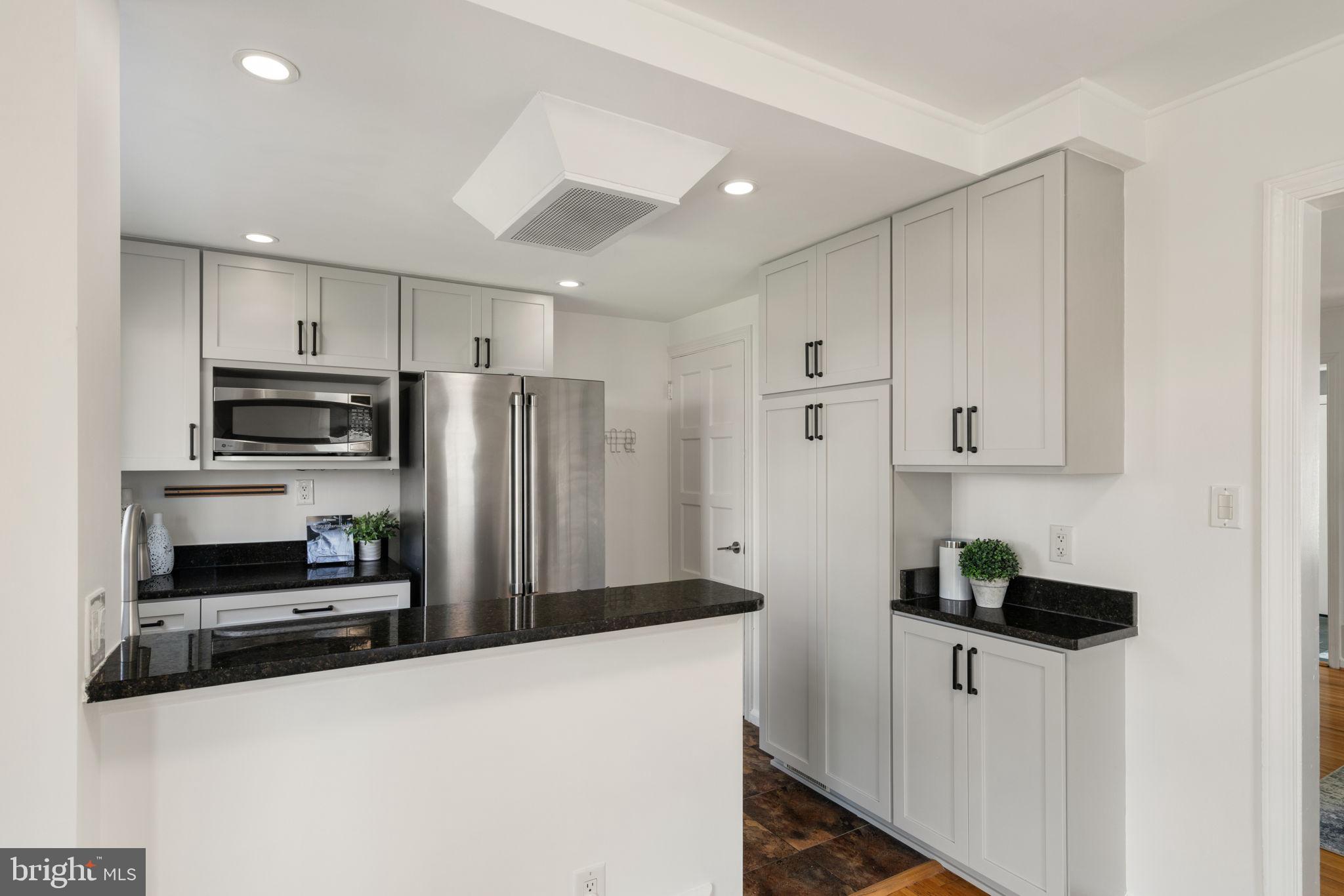6021 Williamsburg Road Alexandria, VA 22303 - Photo 14 of 44 a kitchen with granite countertop a refrigerator and a stove top oven