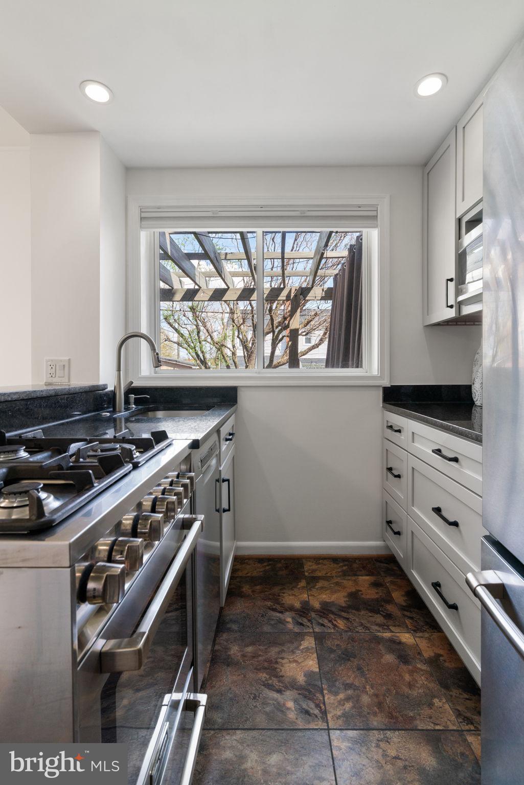6021 Williamsburg Road Alexandria, VA 22303 - Photo 16 of 44 a kitchen with wooden cabinets and a stove top oven
