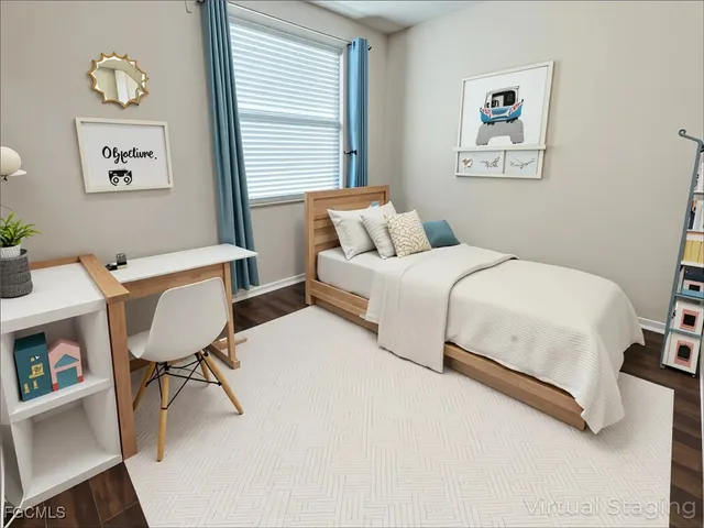 a bedroom with a bed and a table in it with window