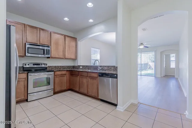 a kitchen with stainless steel appliances granite countertop a refrigerator and a stove top oven