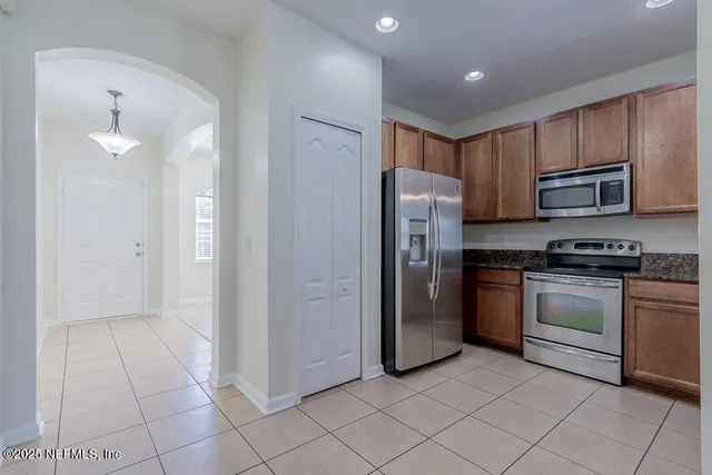 a kitchen with stainless steel appliances granite countertop a refrigerator and a sink