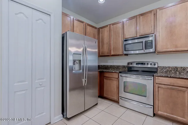 a kitchen with kitchen island granite countertop stainless steel appliances a sink and cabinets